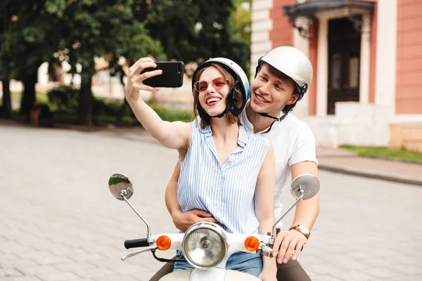 Cheerful Young Couple Crash Helmets Making Selfie Smartphone While Sitting — Stock Photo, Image
