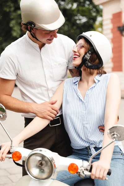 Vertikales Bild Eines Fröhlichen Jungen Paares Sturzhelmen Das Mit Motorroller — Stockfoto