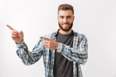 Üzerinde beyaz izole ayakta, parmak uzakta işaret bir gülümseyen Genç sakallı bir adam portresi