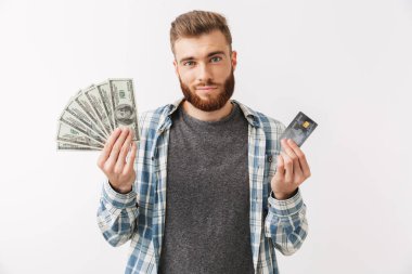 Para banknot ve kredi kartı gösteren beyaz üzerinde izole bir gülümseyen Genç sakallı adam ayakta portresi