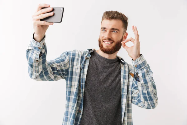 陽気な若い髭の男の白で隔離された立って撮影 Selfie を示す肖像画 — ストック写真