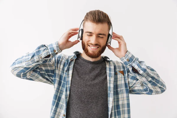 在衬衫和耳机听音乐的快乐胡子男子在灰色背景下闭上眼睛 — 图库照片