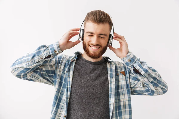 ジョイフルひげを生やした男のシャツとヘッドフォンで聴く音楽を目を閉じて灰色の背景 — ストック写真