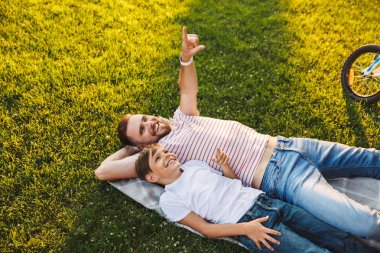 Mutlu genç adam baba resim var bir dinlenme parkı işaret içinde açık havada oğluyla.