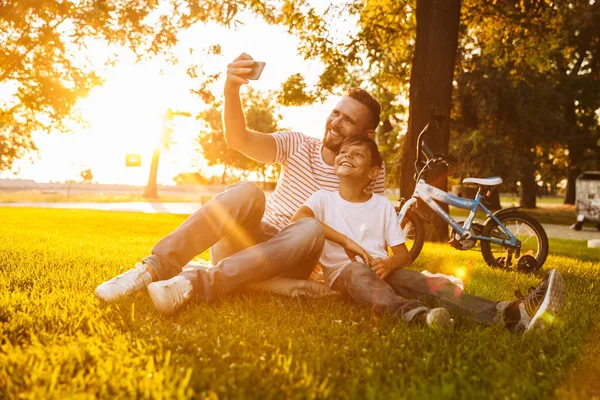 Feliz Padre Hijo Divirtiéndose Juntos Parque Verde Tomando Una Selfie — Foto de Stock