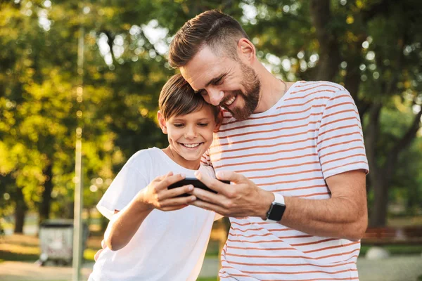 Boldog Apa Tölteni Időt Kis Fia Parkban Látszó Mozgatható Telefon — Stock Fotó