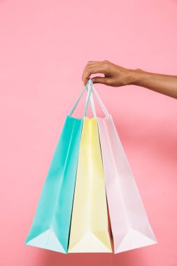 Alışveriş torbaları elinde pembe bir arka plan üzerinde izole kadın resim kırpılmış.