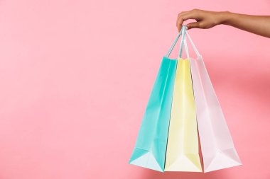 Paketleri satın almalarla pembe arka plan üzerinde tutan kadın resim kırpılmış