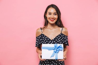 Photo of happy woman isolated over pink background holding susprise gift box. clipart