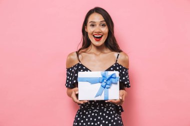 Photo of happy excited emotinal woman isolated over pink background holding susprise gift box. clipart
