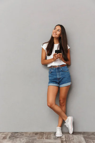 Foto Una Joven Feliz Aislada Sobre Fondo Gris Usando Teléfono — Foto de Stock