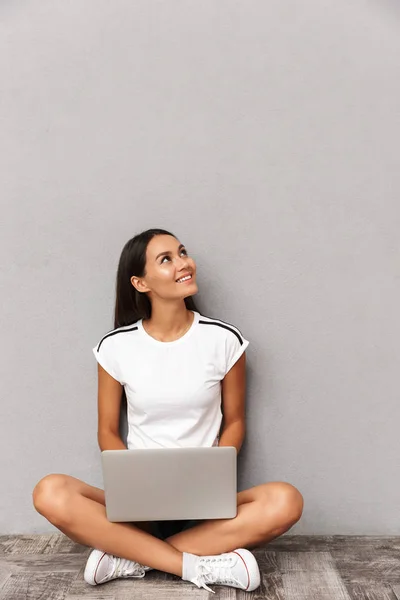 Imagem Jovem Mulher Feliz Sentada Isolada Sobre Fundo Cinza Usando — Fotografia de Stock