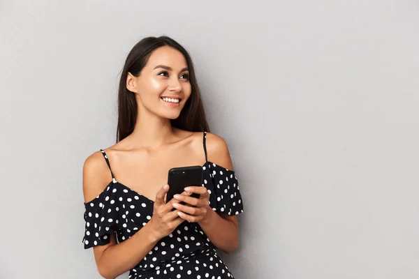 Foto Uma Jovem Feliz Isolada Sobre Fundo Cinza Usando Telefone — Fotografia de Stock