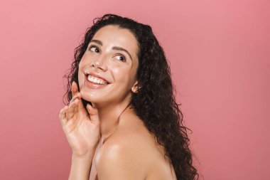 Uzağa arıyorsunuz bir baştan çıkarıcı genç üstsüz kadın kıvırcık esmer saçlı pembe arka plan üzerinde poz Güzellik Portresi