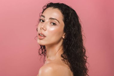 Genç, baştan çıkarıcı bir üstsüz kadın kıvırcık esmer saçlı pembe arka plan üzerinde poz Güzellik Portresi