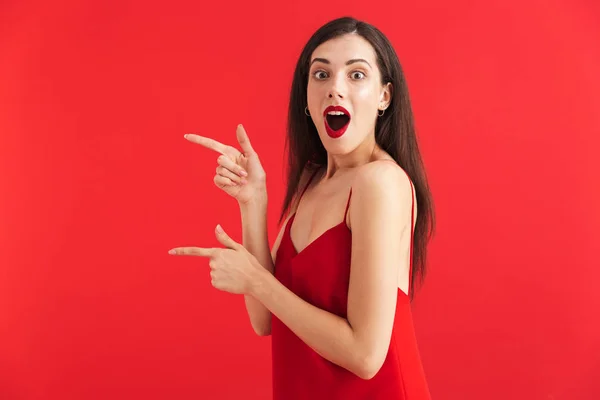 Retrato Uma Jovem Excitada Vestido Isolado Sobre Fundo Vermelho Apontando — Fotografia de Stock