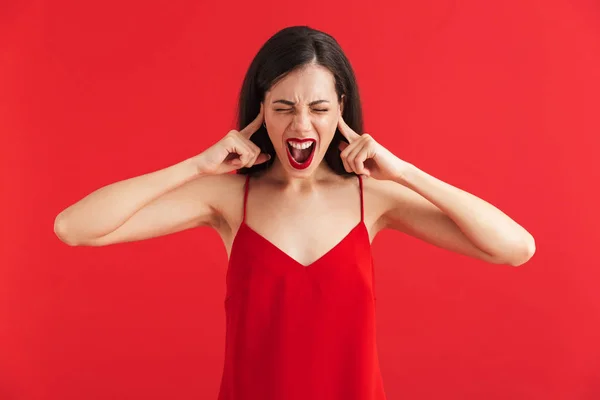 Портрет Роздратованої Молодої Жінки Сукні Ізольованої Червоному Тлі Покриває Вуха — стокове фото
