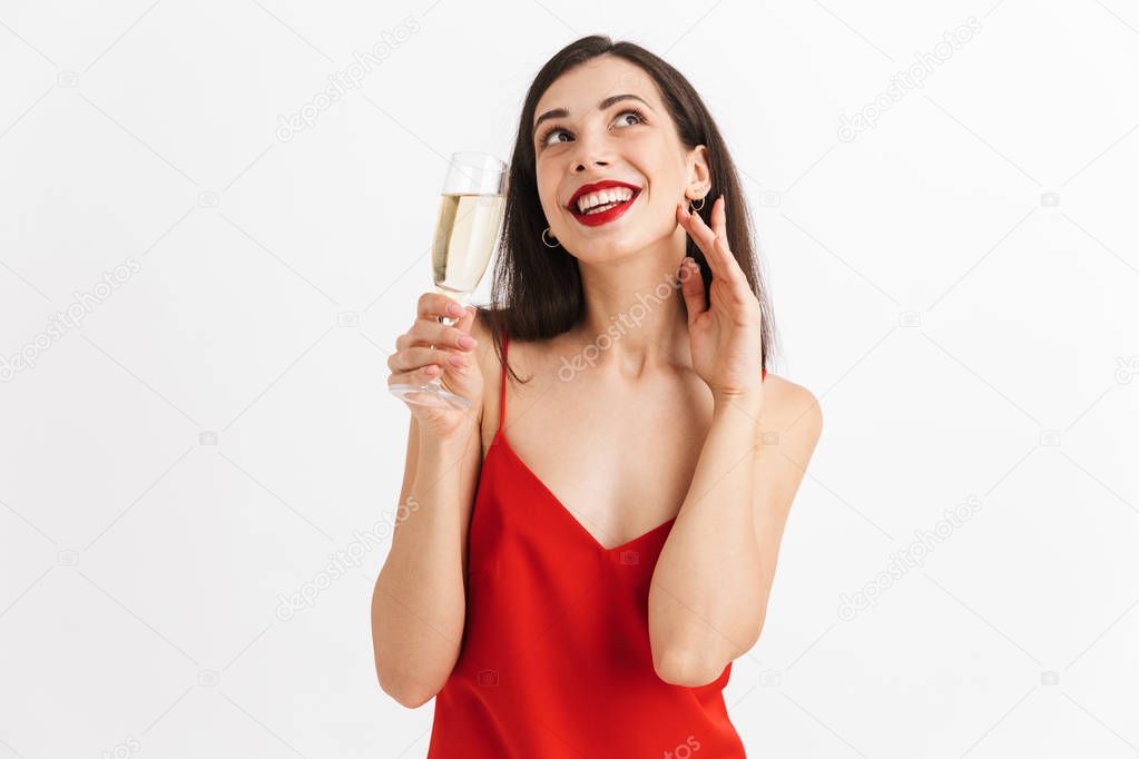 Portrait of a lovely young woman in dress holding glass of champagne isolated over white background