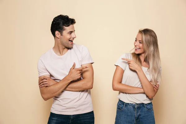 Retrato Jovem Casal Sorrindo Juntos Sobre Fundo Bege Apontando Para — Fotografia de Stock