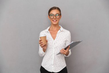Kahve içme gri duvar arka plan holding Pano üzerinde duran güzel iş kadın görüntüsünü.