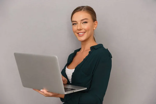 Hübsche Junge Geschäftsfrau Die Vor Grauem Hintergrund Steht Und Laptop — Stockfoto