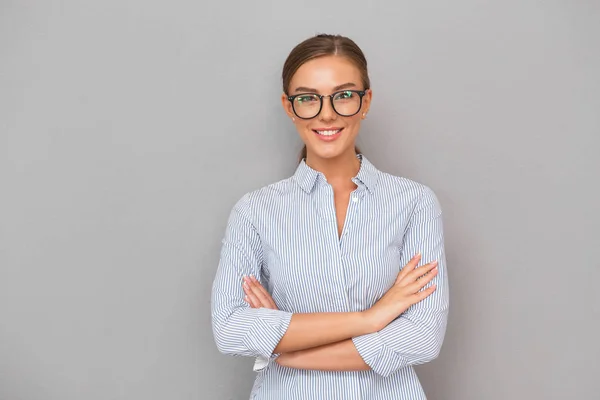 灰色の壁背景ポーズで立っている幸せなビジネス女性のイメージ — ストック写真
