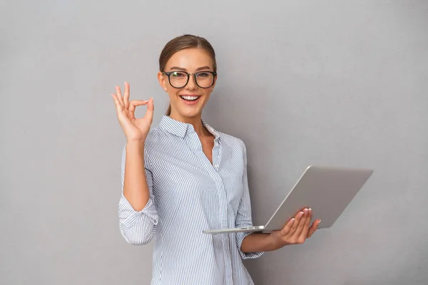 Glückliche Junge Geschäftsfrau Steht Über Grauem Hintergrund Arbeitet Laptop Zeigt — Stockfoto