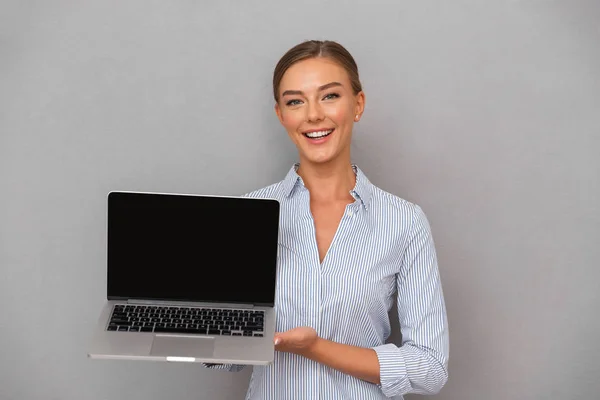 Feliz Joven Empresaria Pie Sobre Fondo Gris Mostrando Computadora Portátil —  Fotos de Stock