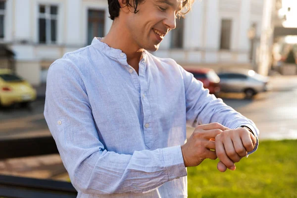 Sonriente Joven Hombre Casual Ajustando Reloj Inteligente Mientras Camina Por — Foto de Stock