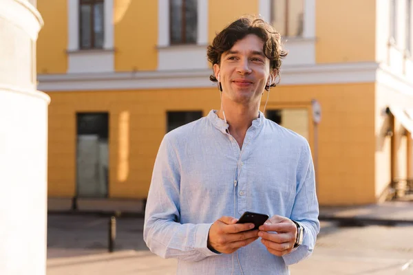 Leende Ung Casual Man Håller Mobiltelefon Medan Promenader Staden Gatan — Stockfoto
