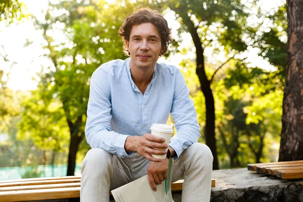 Attractive Young Casual Man Holding Newspaper While Sitting City Park — Stock Photo, Image