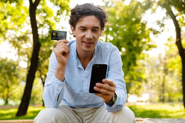 Kredi Kartı Gösteren Şehir Parkta Otururken Cep Telefonu Tutan Memnun — Stok fotoğraf