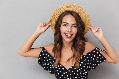 Görüntü gri duvardan kamera seyir şapka neşeli Genç Sevimli Kadın.