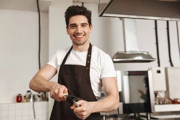 Glücklicher Junger Mann Koch Schürze Steht Der Küche Und Schärft — Stockfoto