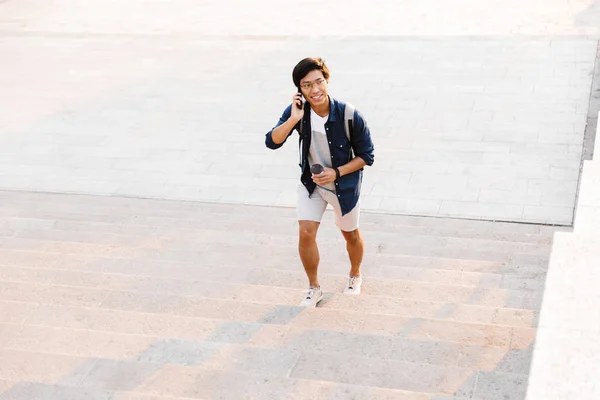 Sonriendo Asiático Hombre Hablando Móvil Mientras Caminando Arriba Aire Libre — Foto de Stock
