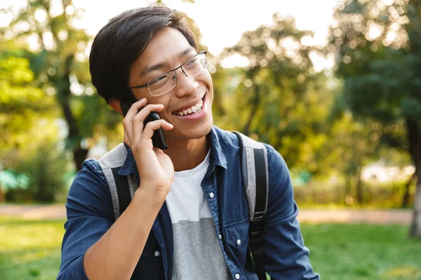 Lächelnder Asiatischer Student Mit Brille Der Smartphone Spricht Und Park — Stockfoto