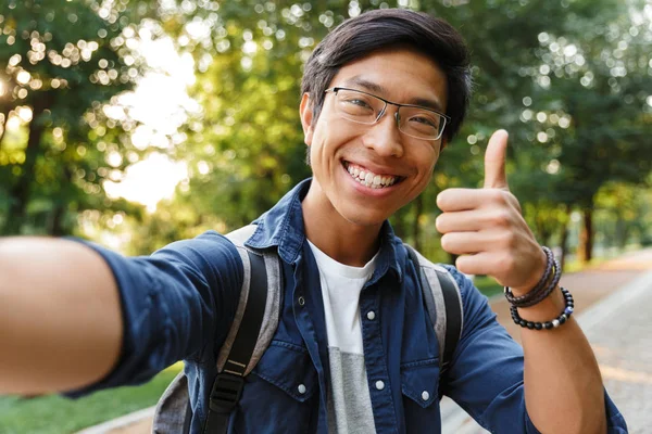 Feliz Asiático Estudante Masculino Óculos Fazendo Selfie Mostrando Polegar Para — Fotografia de Stock