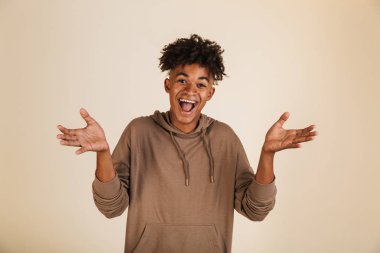 Bir gülümseyen genç afro Amerikalı adam portresi izole omuzlarında shrugging hoodie giyinmiş
