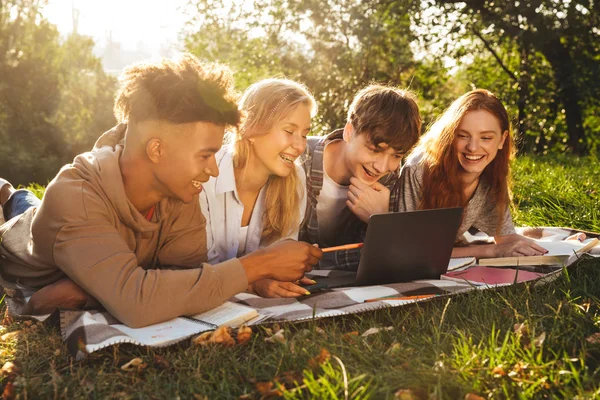 Grupo Estudiantes Multiétnicos Felices Haciendo Los Deberes Juntos Parque Utilizando —  Fotos de Stock