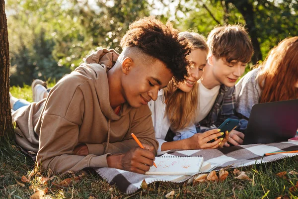 Gruppo Studenti Multietnici Sorridenti Che Fanno Compiti Insieme Parco Usando — Foto Stock