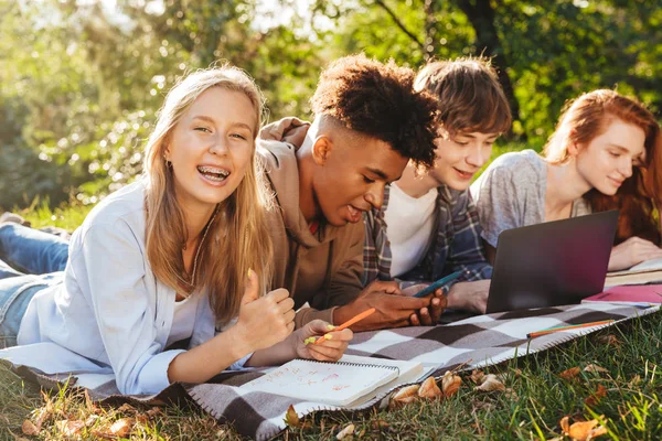 Grupo Estudiantes Multiétnicos Positivos Haciendo Los Deberes Juntos Parque Utilizando — Foto de Stock