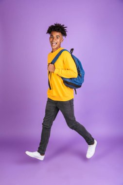 Neşeli bir genç afro Amerikalı adam portresi tam uzunlukta yürüyüş izole, sırt çantası taşıyan kazak giymiş