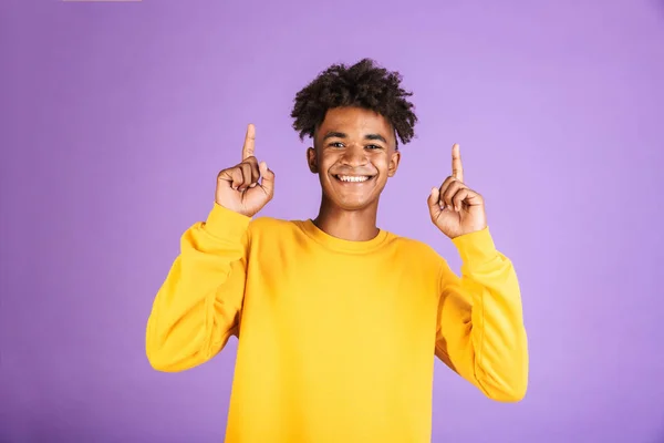 一个微笑的年轻美国黑人男子的肖像身着运动衫指向孤立的手指 — 图库照片