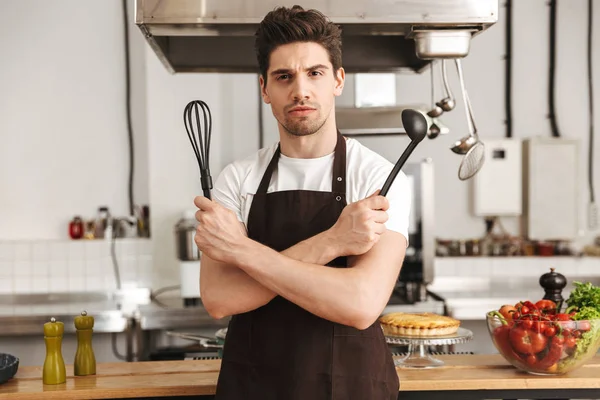 Sebevědomý Mladý Muž Kuchaře Vařit Zástěře Stojí Kuchyni Naběračku Metla — Stock fotografie