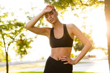 Görüntü bir yorgun sıkılmış genç sarışın kadın park açık havada spor.