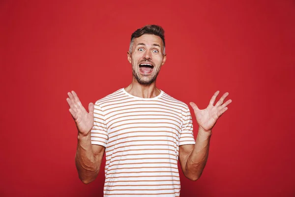 Gioioso Uomo Righe Shirt Ridere Alzando Mani Isolate Sfondo Rosso — Foto Stock