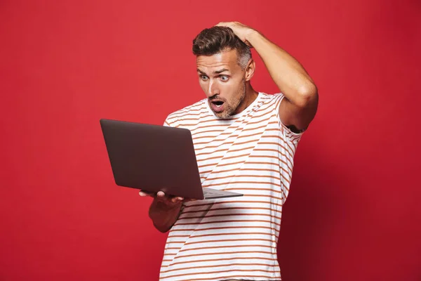 Imagen Hombre Adulto Frustrado Camiseta Rayada Sonriendo Sosteniendo Portátil Gris — Foto de Stock