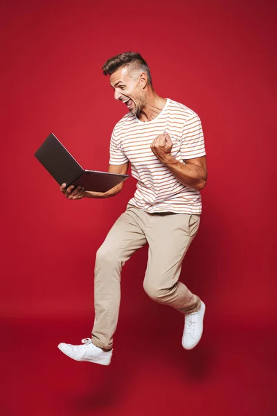 Foto Cuerpo Entero Hombre Caucásico Camiseta Rayada Sonriendo Sosteniendo Portátil — Foto de Stock