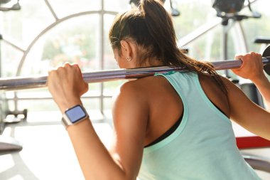Arkadan görünüşü harika spor kadın egzersiz halter yakınındaki spor salonu içinde belgili tanımlık pencere ile yapmak