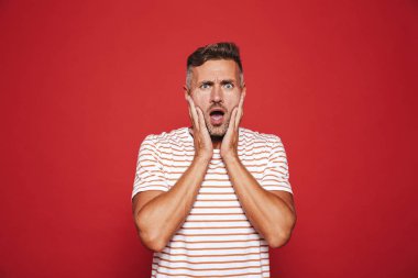 Karışıklık ve izole kırmızı arka plan üzerinde stres yüzüne kapma sinirli sinirli adam portresi